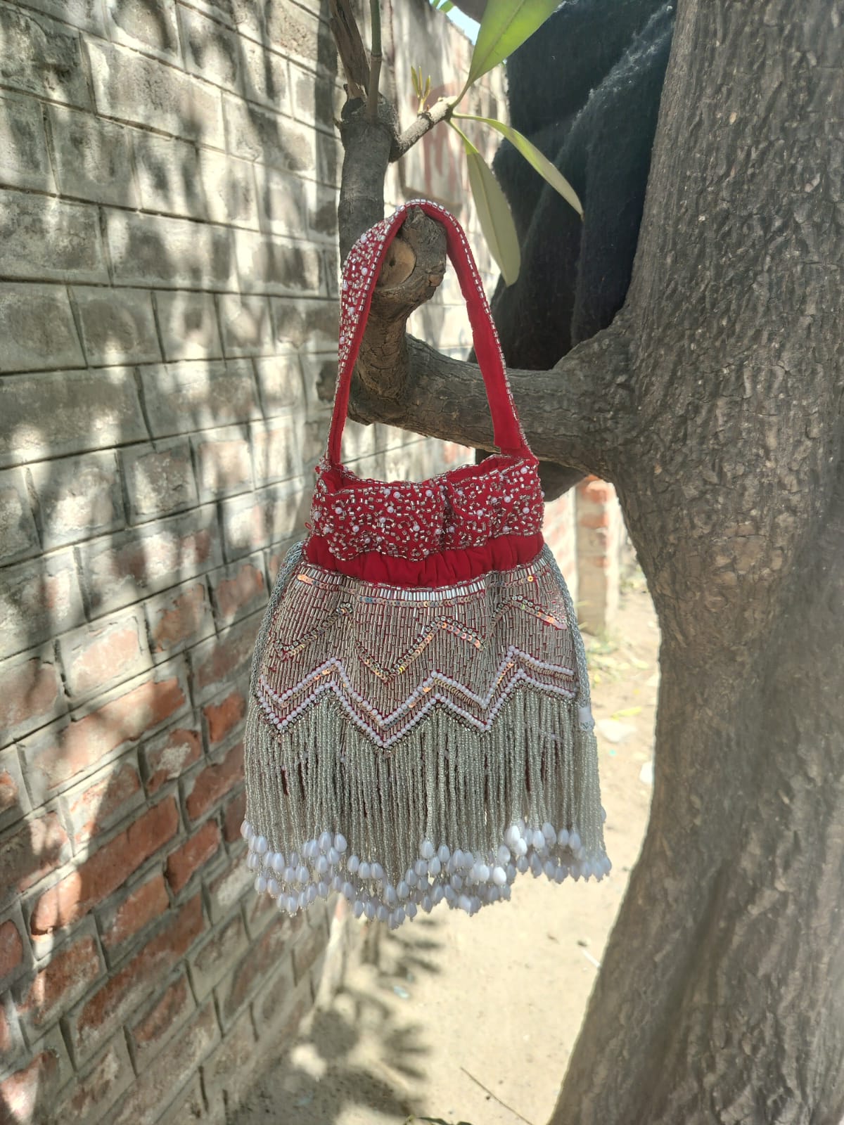 Red Hand Embroidered Bridal Potli Bag with Tassels and Pearl Handle – Festive Wedding Clutch for Women